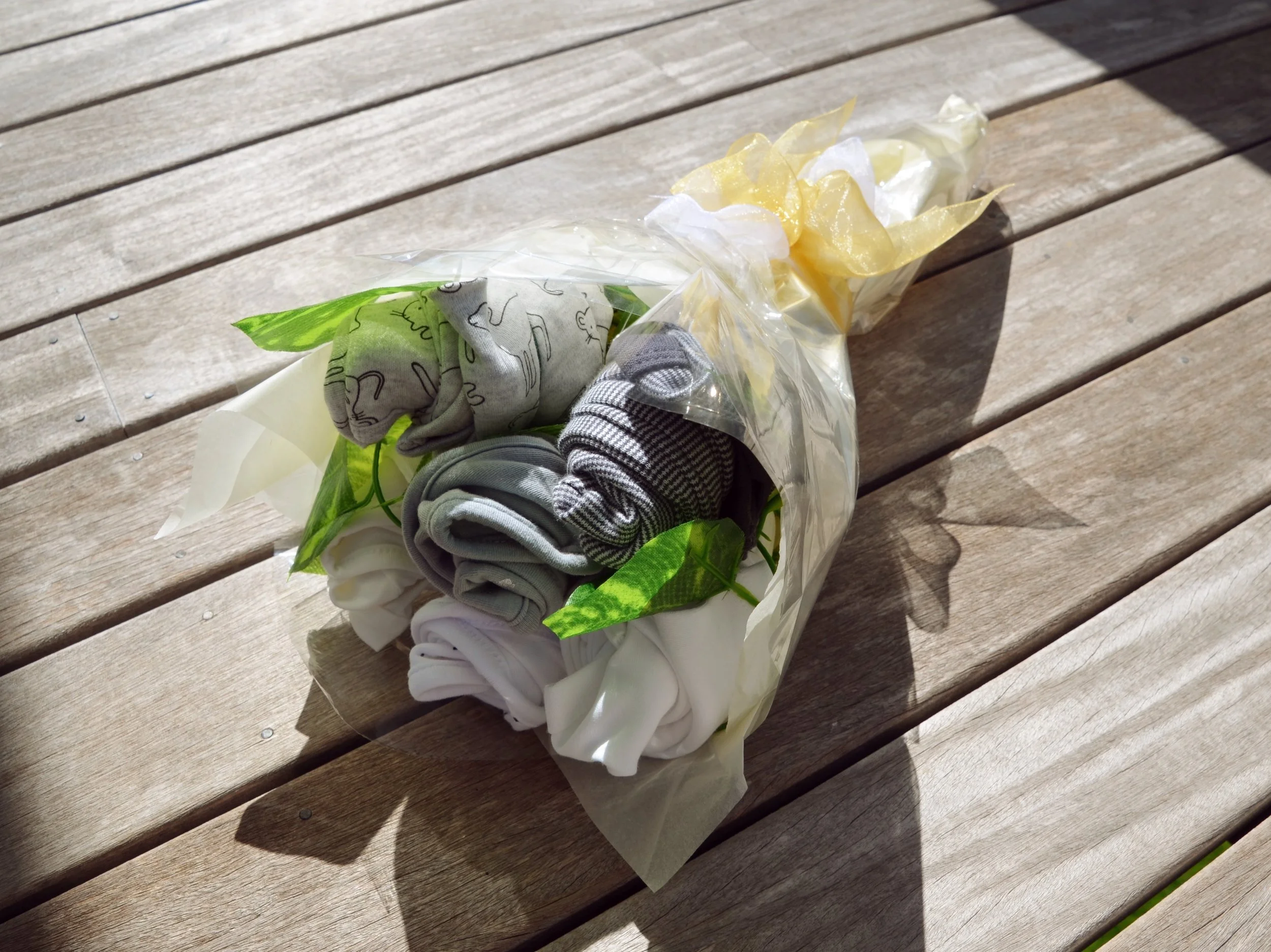 A bouquet made from rolled baby clothes