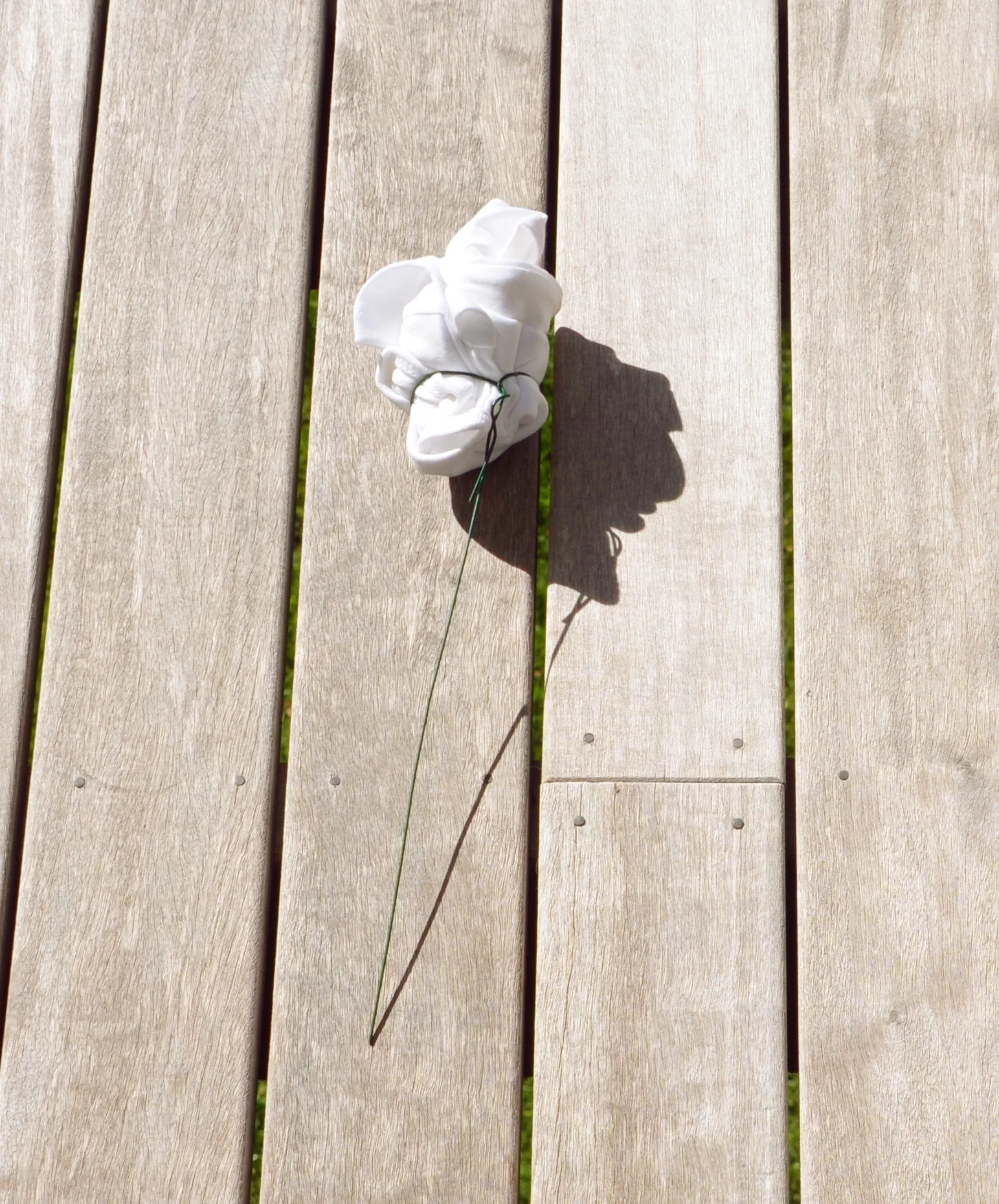 Wire being twisted around the base of a clothing flower