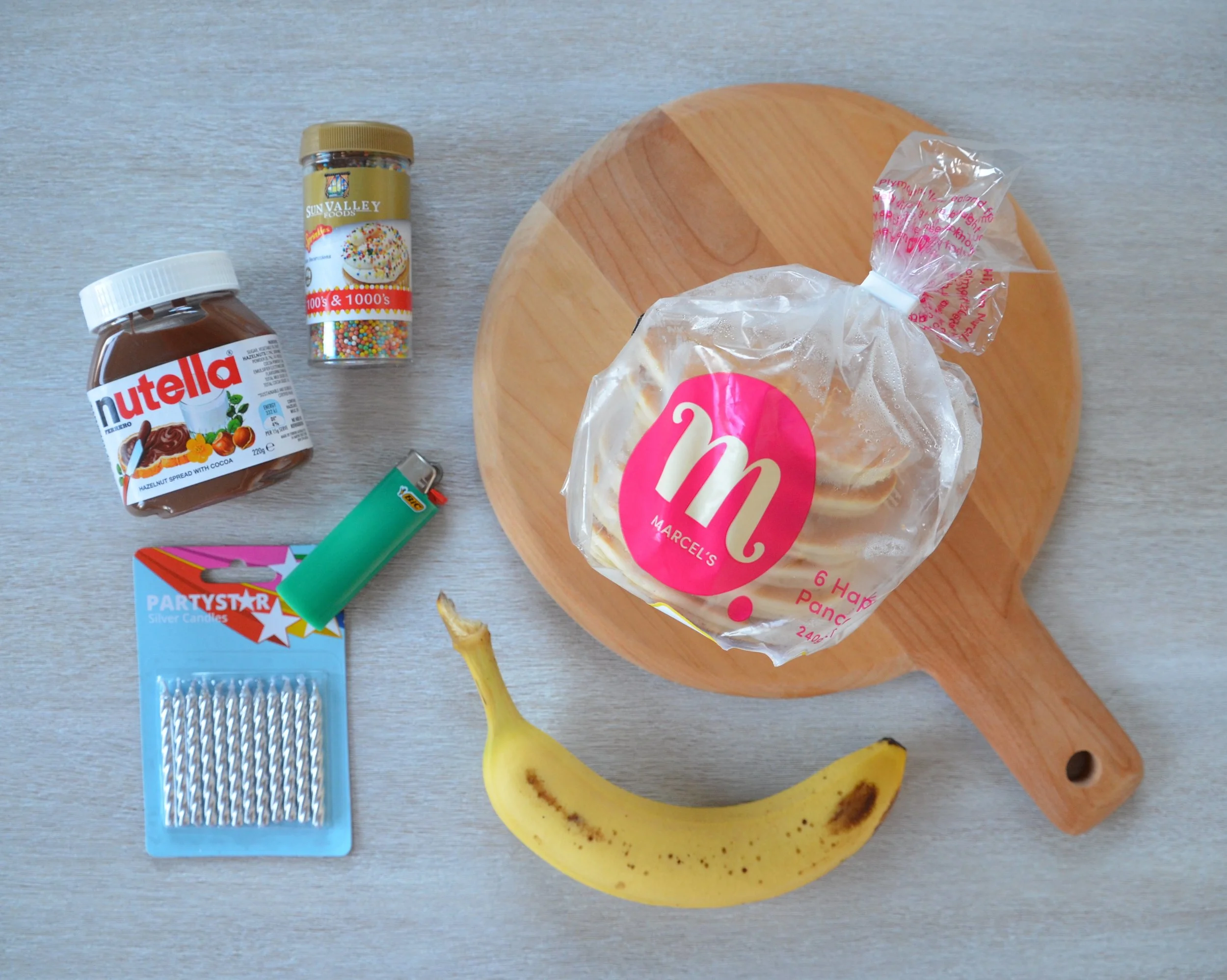 Ingredients laid out: pancakes, Nutella, banana, sprinkles, and candles