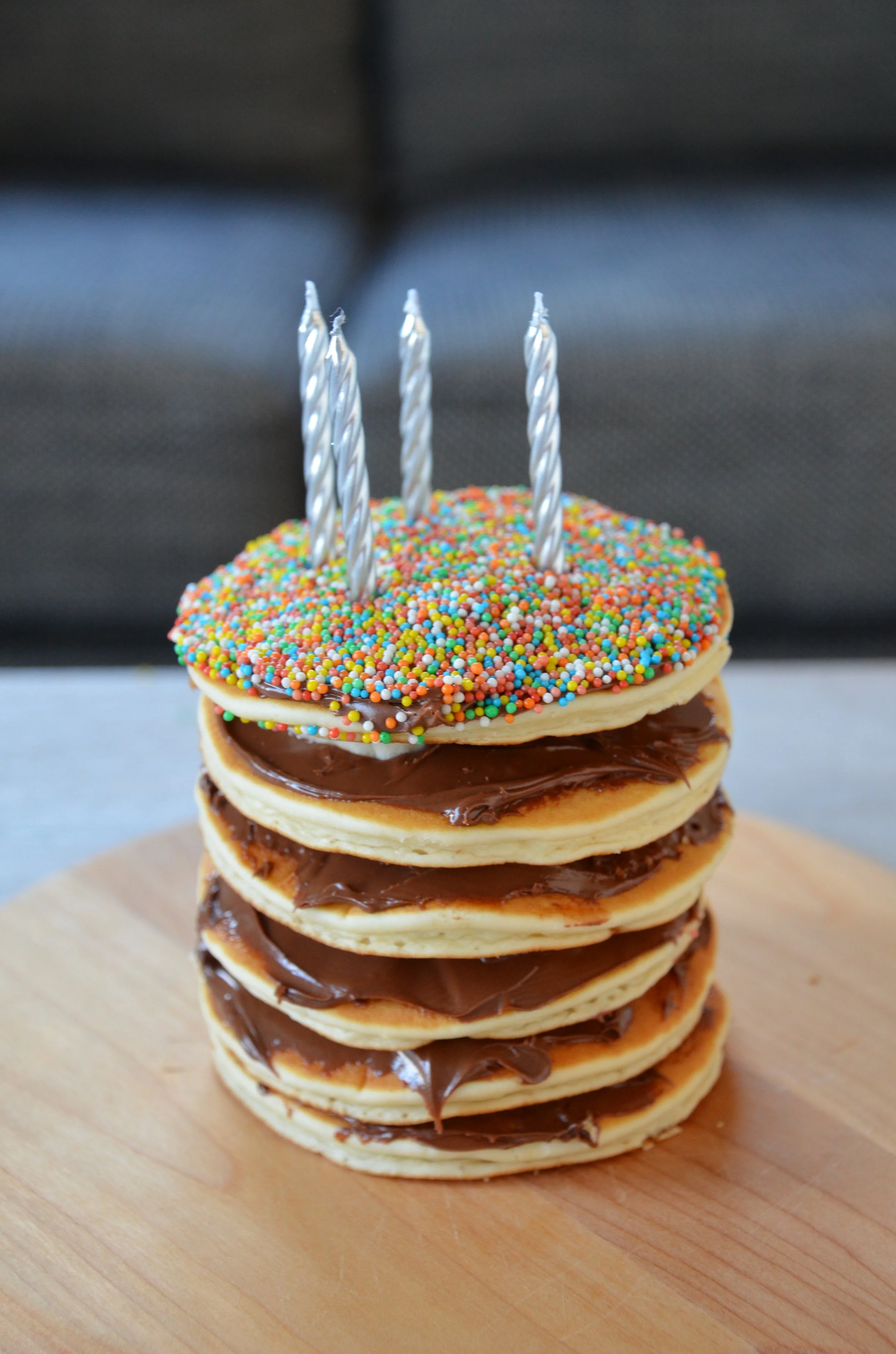 Completed pancake birthday cake with lit candles ready to serve