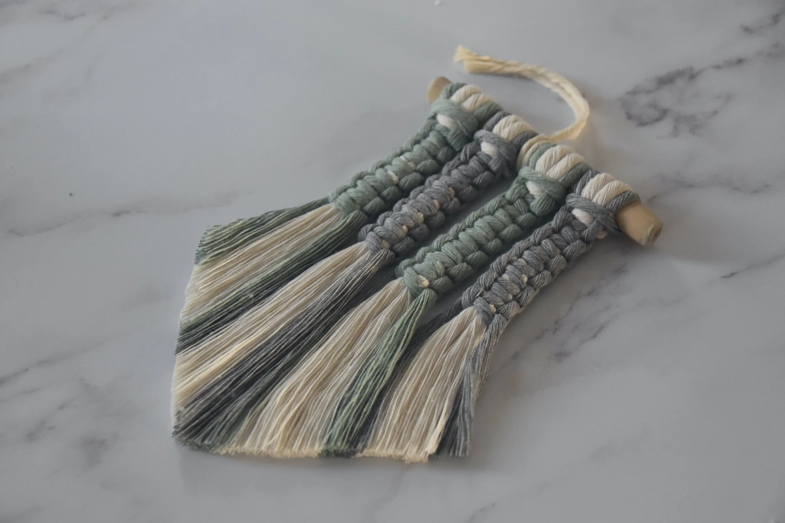 A small macram&eacute; hanging designed for a car rear-view mirror