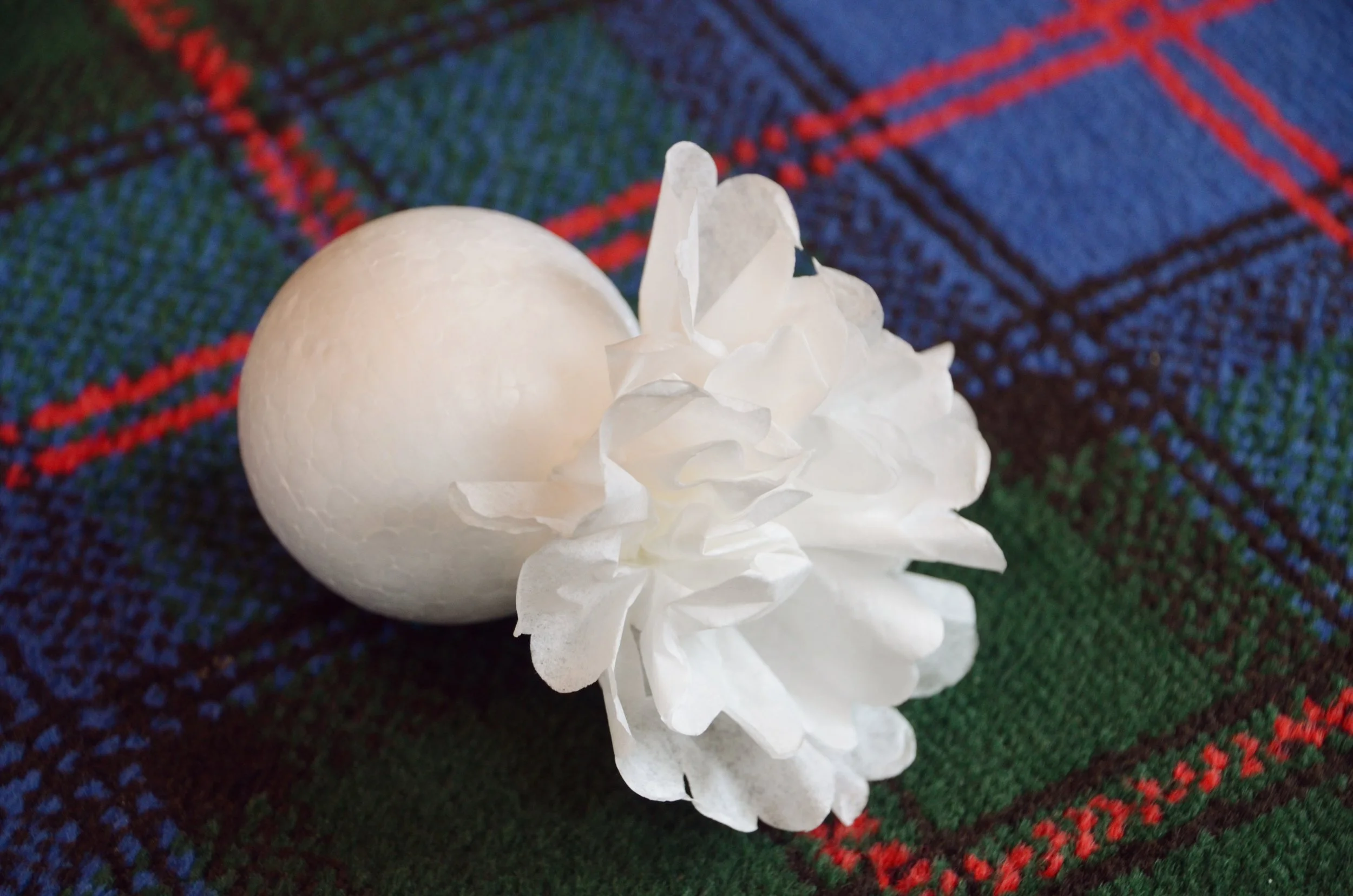 Coffee filter flowers being attached to the polystyrene ball