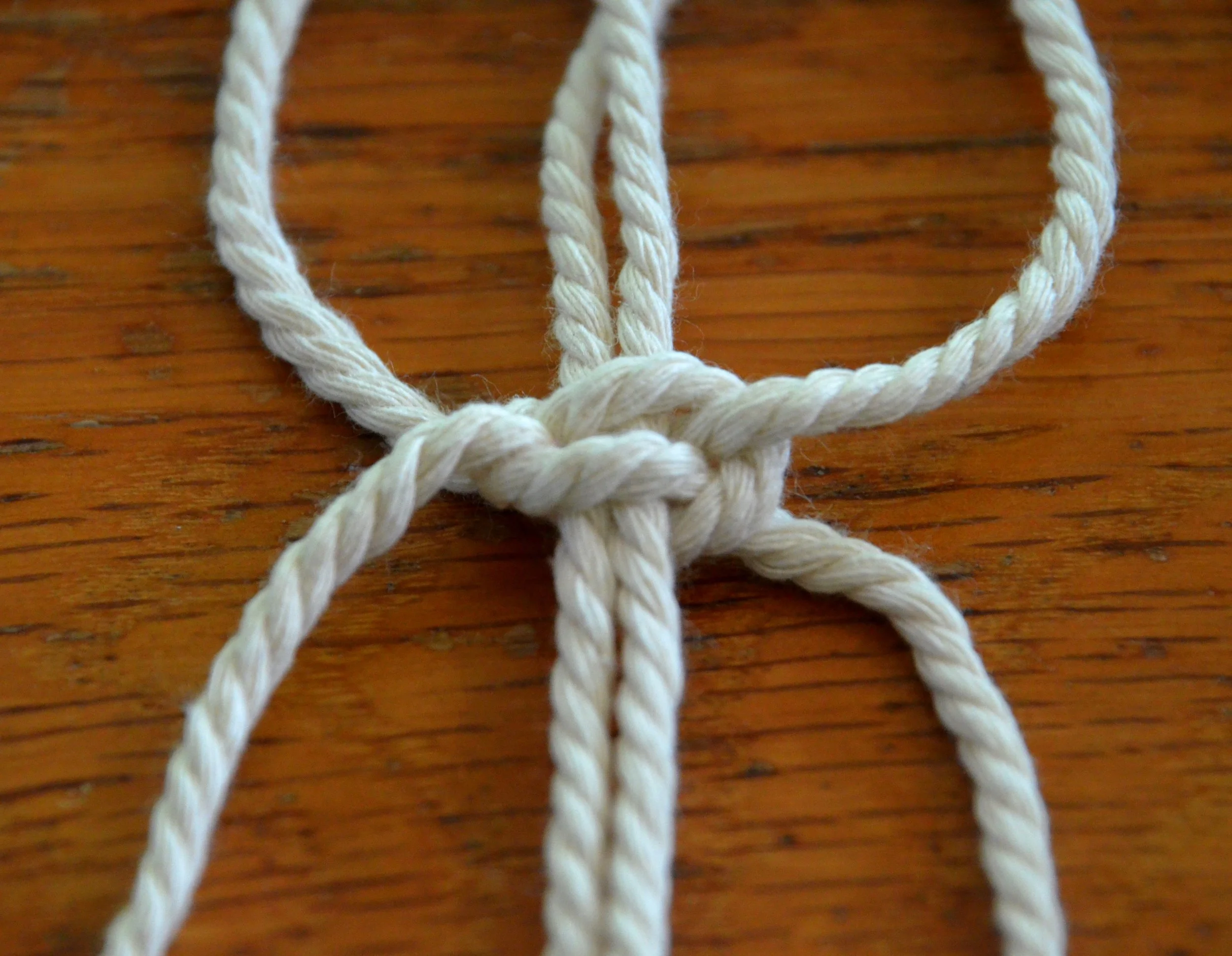 Lark's Head knot attaching cord to a wooden rod