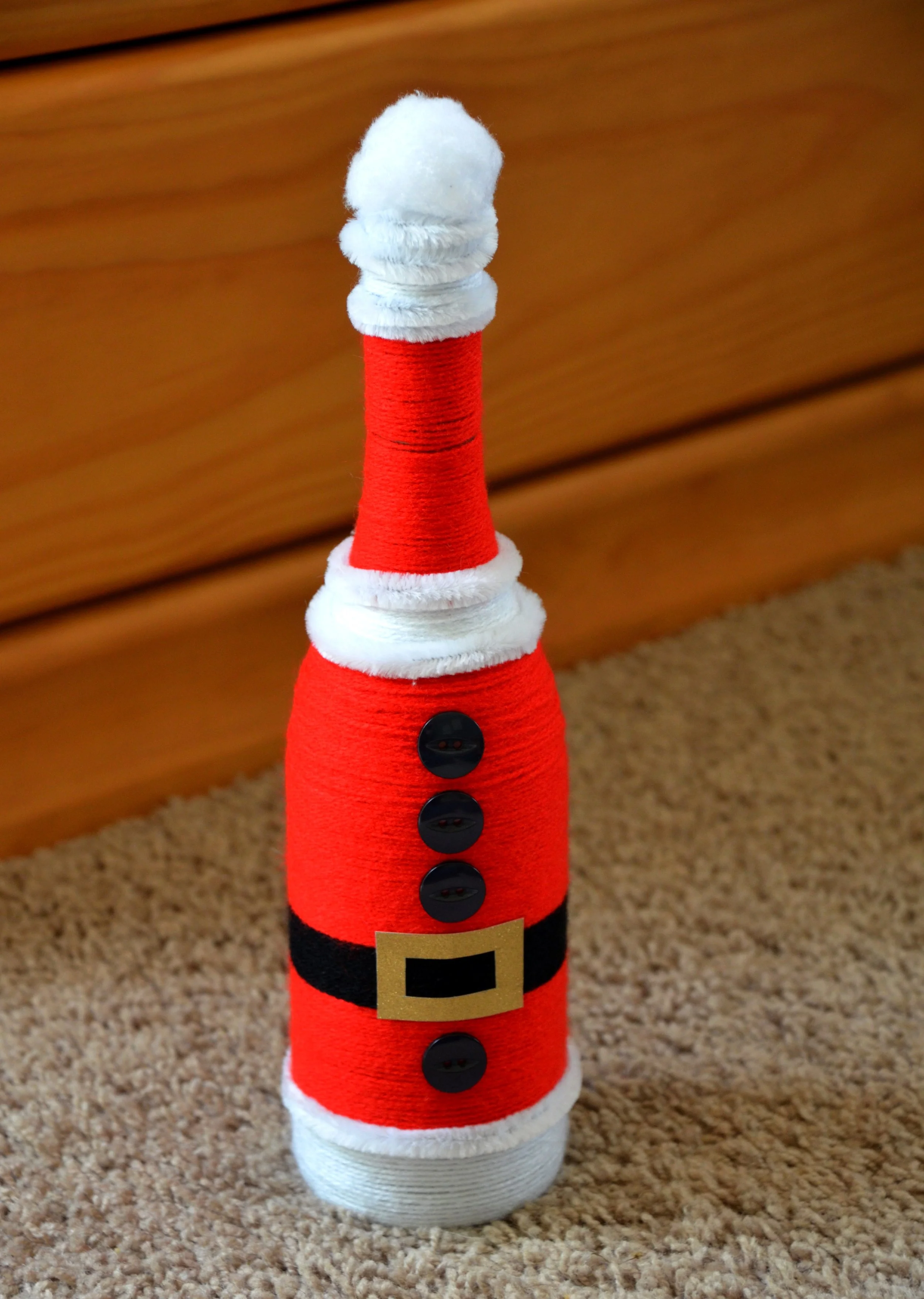 A wine bottle wrapped in wool to look like Santa