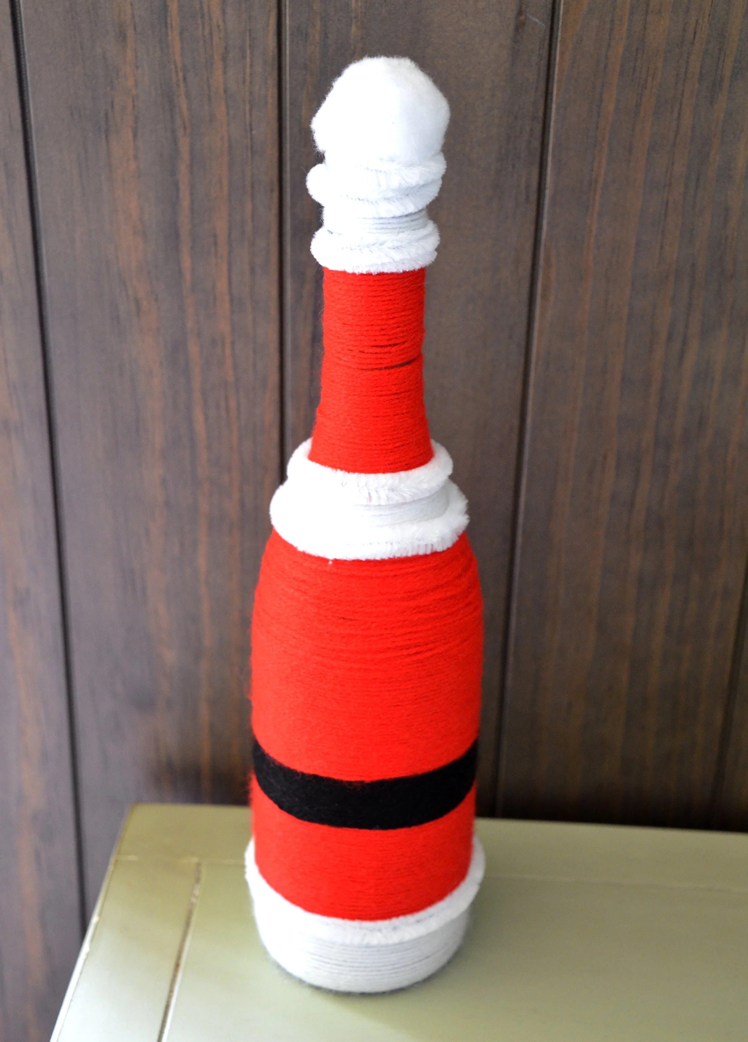 Double-sided tape being applied around the base of the bottle