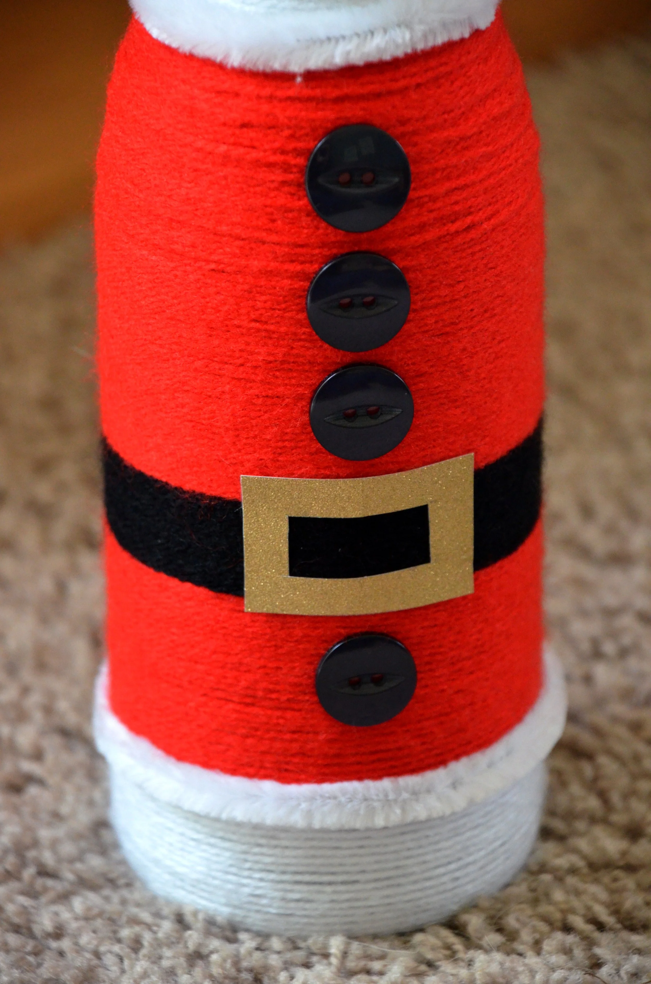 White wool wrapped around the bottle lid with a pom pom on top