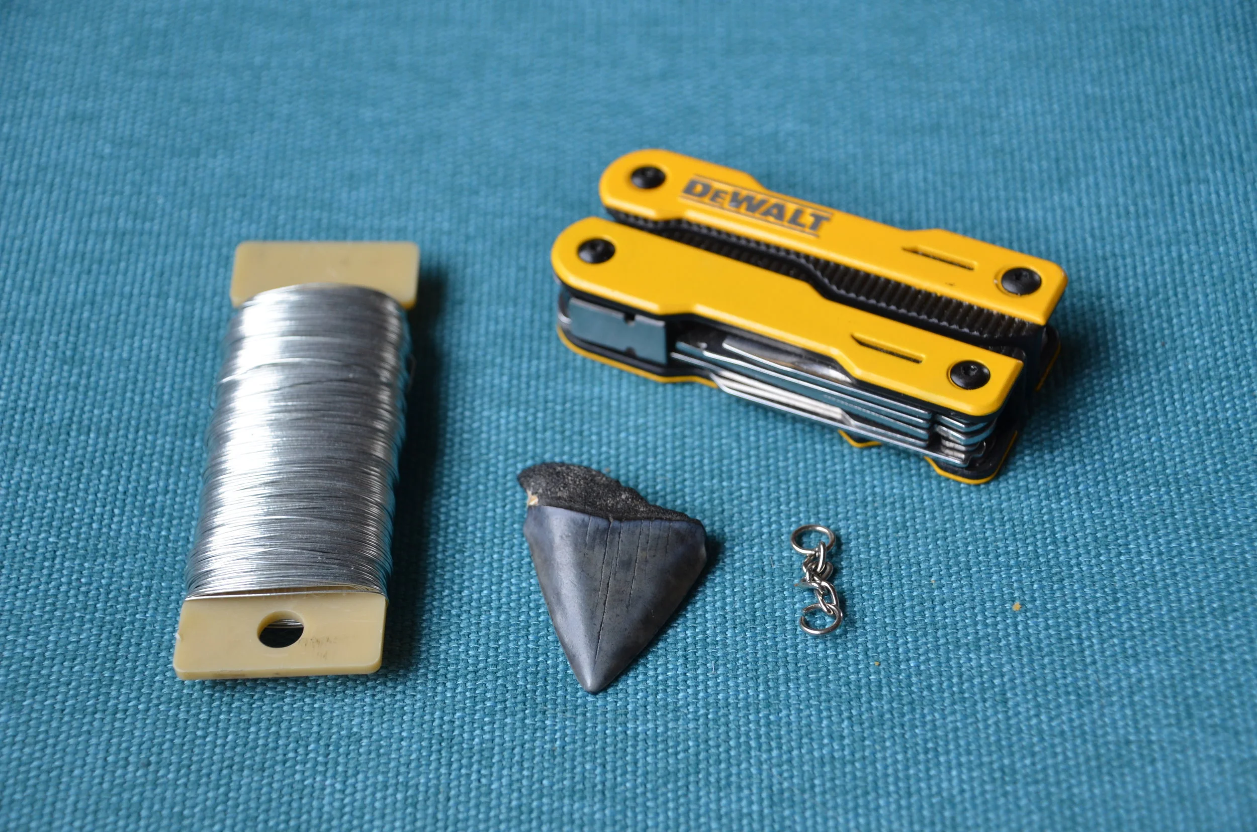 Craft wire being wrapped around the shark tooth