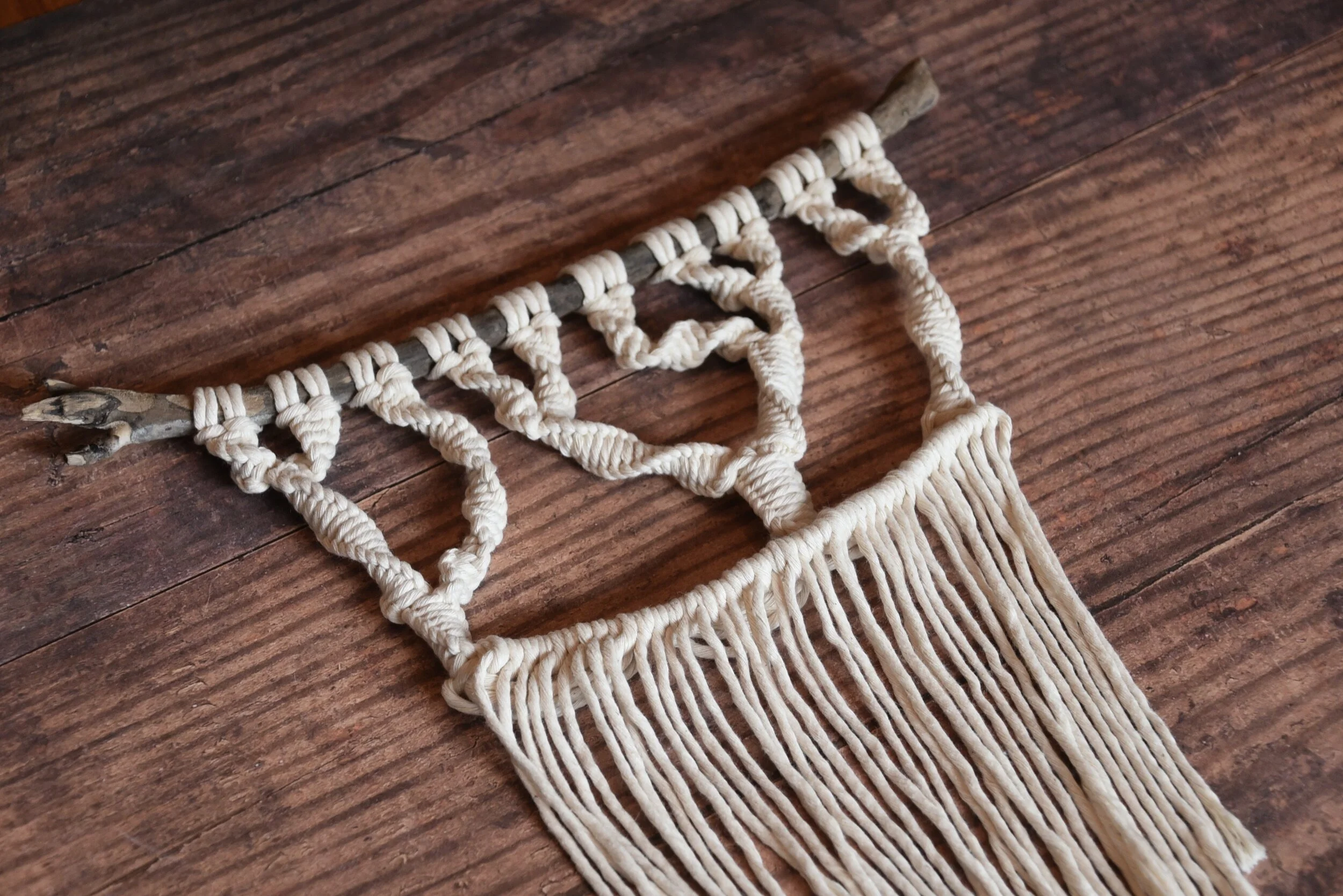 A macram&eacute; wall hanging featuring tree silhouettes